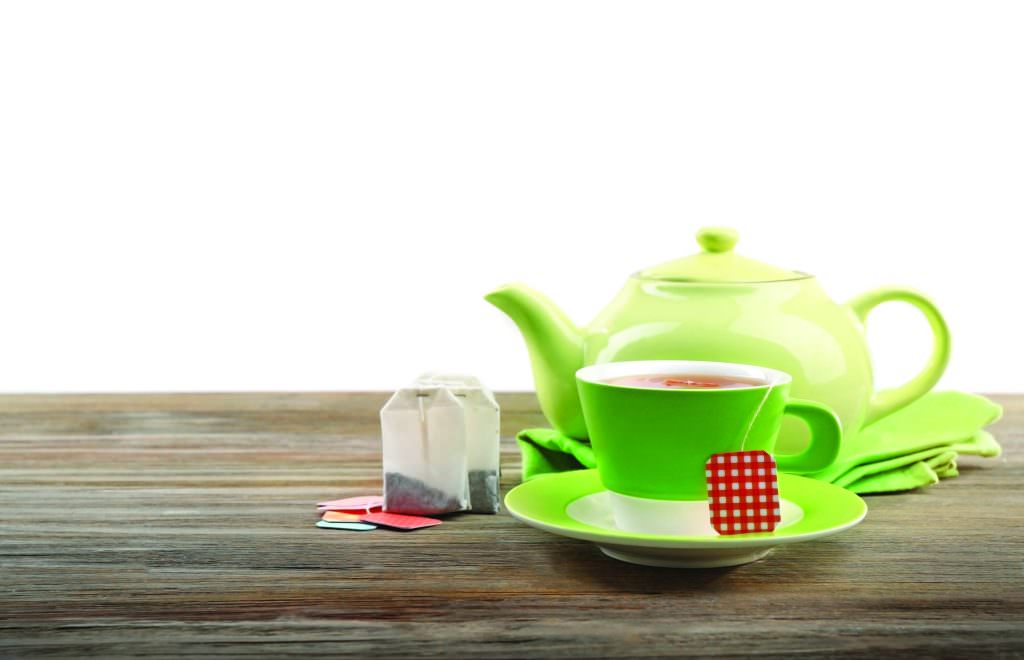 Teapot with cup of tea and tea bags